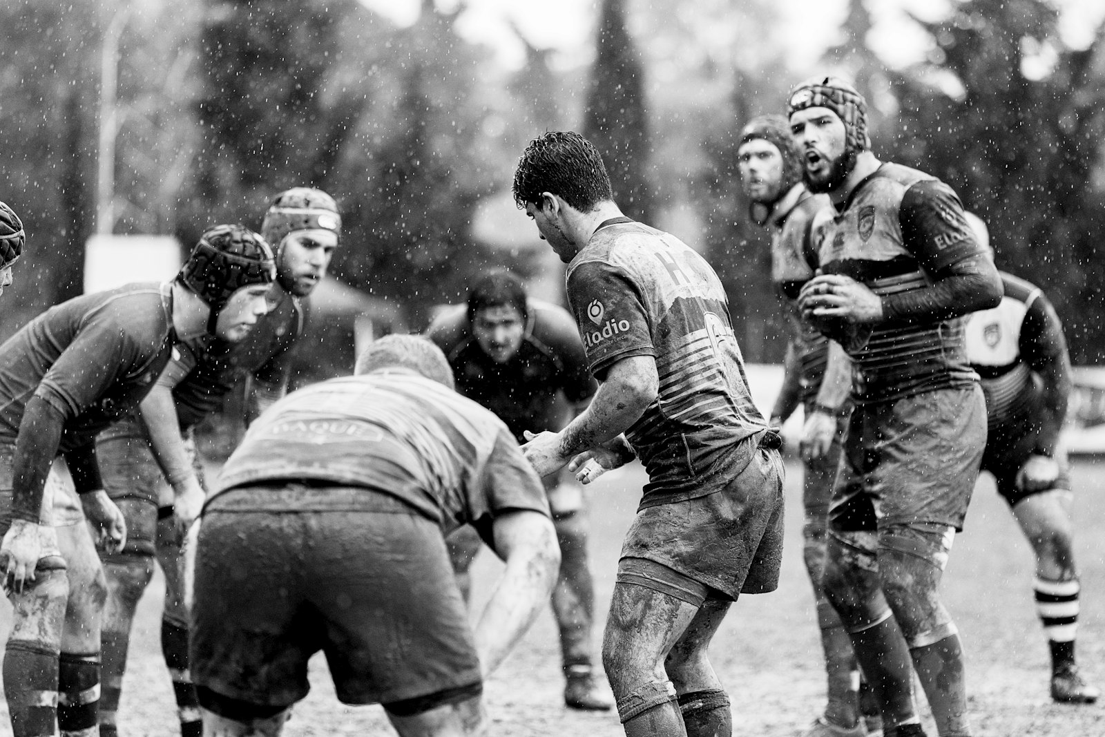 Rugby players competing in wet, muddy conditions