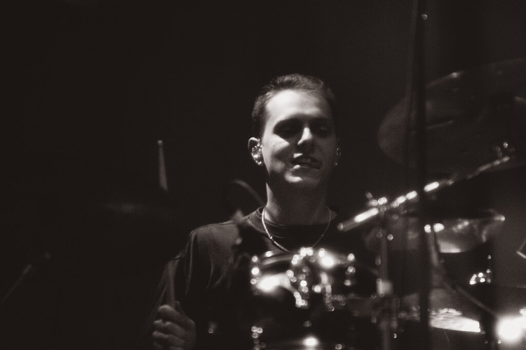 Black-and-white portrait of a Balu Brigada drummer behind the kit.