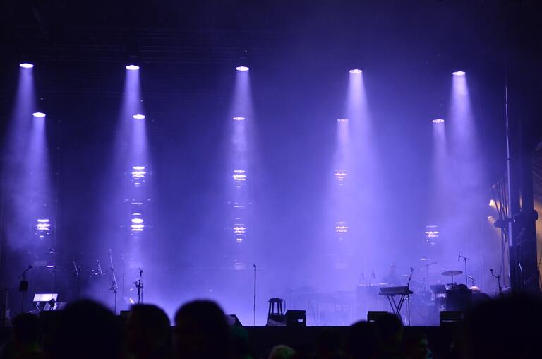Illustrative live concert stage with purple lighting and haze